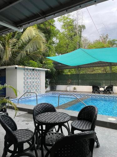 a patio with tables and chairs next to a swimming pool at PDR Resort 