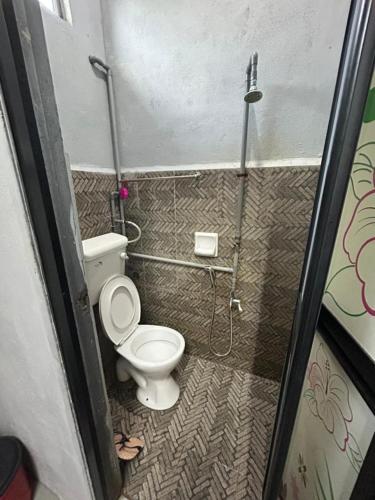 a small bathroom with a toilet and a shower at CILI PADI GUESTHOUSE in Kota Bharu