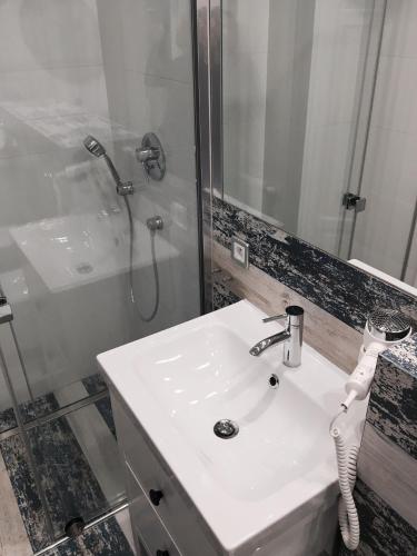 a bathroom with a white sink and a shower at Willa Błękit Hotel by Dorota Szelągowska in Mielno