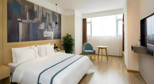 a hotel room with a large bed and a television at City Comfort Inn Changsha South Railyway Station West Square in Changsha