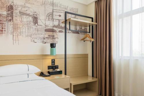 a bedroom with a bed and a drawing on the wall at City Comfort Inn Changsha South Railyway Station West Square in Changsha