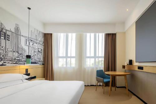 a hotel room with a bed and a table and a tv at City Comfort Inn Changsha South Railyway Station West Square in Changsha