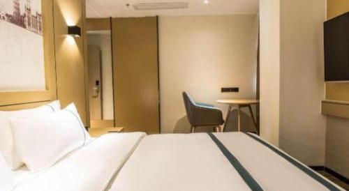 a hotel room with a bed and a table at City Comfort Inn Liuzhou Liucheng in Liuzhou