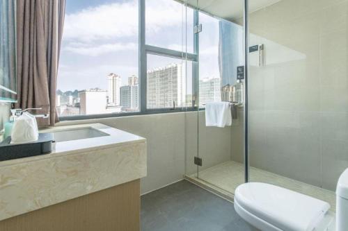 a bathroom with a shower and a toilet and a window at City Comfort Inn Liuzhou Liucheng in Liuzhou