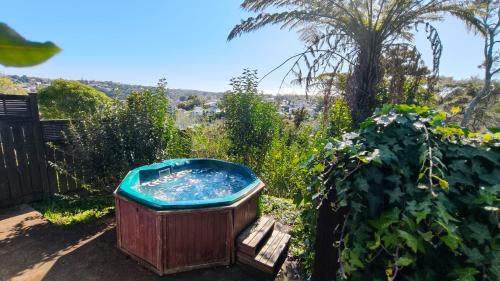 a wooden bath tub sitting in a garden at Spa Retreat Spacious 7 BRS 3 Baths Movie Lounge nice Garden with Parking in Auckland