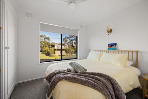 Un dormitorio con una cama y una ventana grande. en Casa Blanca Ventnor Beach, en Ventnor