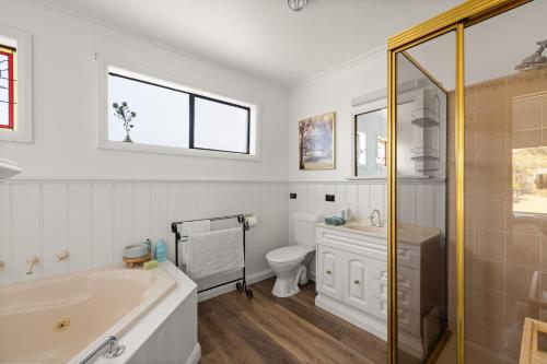 Un baño con bañera, inodoro y lavabo. en Casa Blanca Ventnor Beach, en Ventnor