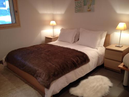 a bedroom with a large bed with a brown blanket at Lakeview 180° in Talloires