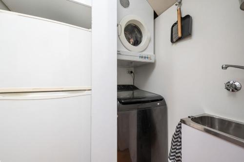 a kitchen with a sink and a washing machine at Deco Days - Prahran in Melbourne