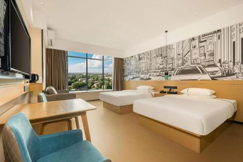 une chambre d'hôtel avec deux lits et un bureau dans l'établissement City Comfort Inn Dandong Railway Station Yalu River Scenic Area, à Dandong