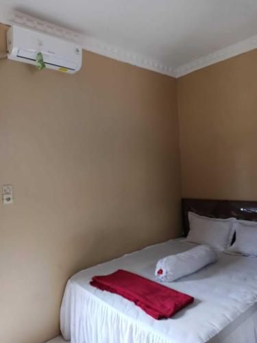 a bedroom with a bed with a red towel on it at Wisma Syariah Rumah Bundo in Padang