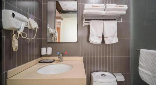 a bathroom with a sink and a toilet and a mirror at Thank Inn Hotel Jiangsu Wuxi High-Tech Zone Ruigang Pedestrian Street in Wuxi