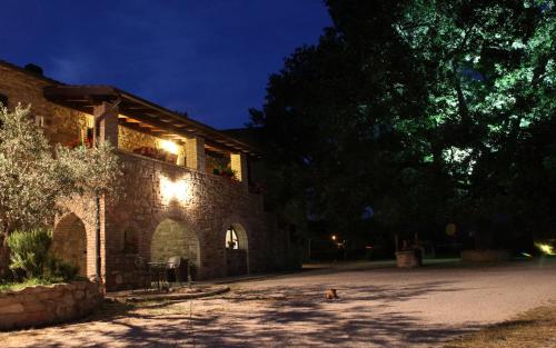 a building with a dog sitting in front of it at Il Casale della Quercia in Assisi