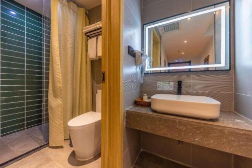a bathroom with a sink and a toilet and a mirror at GreenTree Inn Express Lanzhou West Passenger Station Lanzhou Center in Lanzhou
