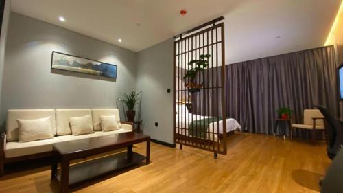 a living room with a white couch and a table at GreenTree Inn Express Datong High-Speed Railway Station Wanda Plaza Fangte in Datong