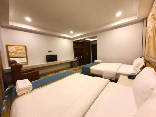 a hotel room with two beds and a television at LSP Hotel in Sihanoukville