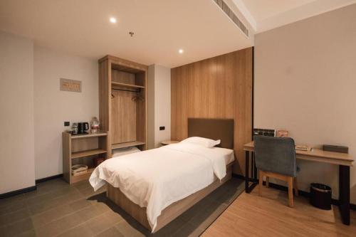 a bedroom with a bed and a desk and a chair at Green Tree Inn Express Inner Mongolia Tongliao Zalute Qi Lubei Town People's Hospital in Jarud