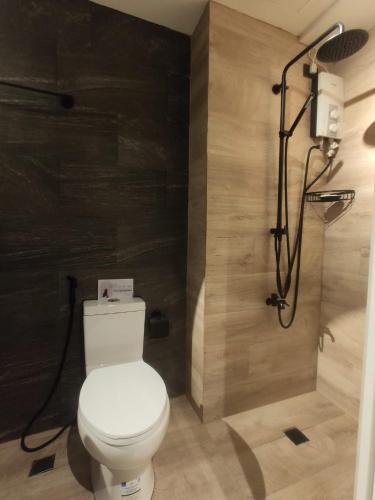 une salle de bain avec des toilettes blanches et une douche dans l'établissement Annas Place Tagaytay, à Kaybagal