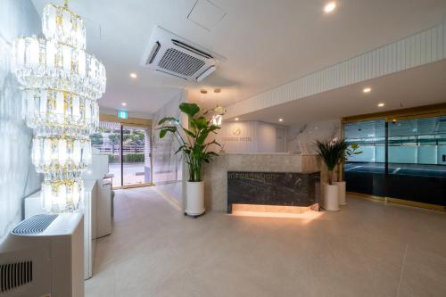 a living room with a chandelier and a fireplace at 그랜디스 호텔 문현 in Busan
