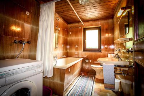 a bathroom with a tub and a sink and a washing machine at Casa Serac´ in La Valle
