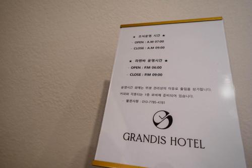 a sign for the grandis hotel on a wall at 그랜디스 호텔 문현 in Busan