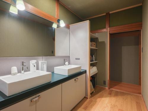 a bathroom with two sinks and a mirror at Enza - Vacation STAY 69573v in Katori