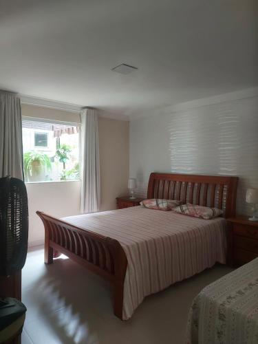 a bedroom with a large bed and a window at Recanto da Sulla - JAUÁ in Jauá