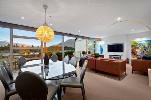 a living room with a glass table and a couch at Taimana Queenstown in Queenstown