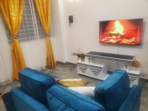 a living room with a couch and a tv at Jay Comfort home- Cozy 1BR next to Village Market, 2 Rivers mall, UN and The Embassies along Limuru Road in Ruaka