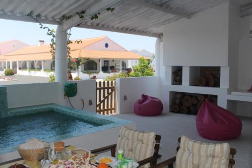 una piscina en un patio con mesa y sillas en Sesmarias Turismo Rural & SPA, en Peroguarda