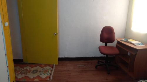 a room with a desk and a chair next to a door at Casa SurOceano Hostal in Valparaíso