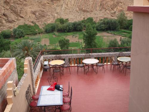 a patio with tables and chairs on a balcony at Maison d'Hôte Valentine in Tinerhir