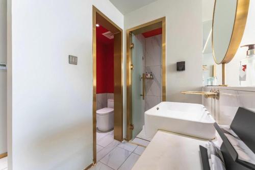a bathroom with a sink and a tub and a toilet at Borrman Hotel Jining High-tech Huangtun in Jining