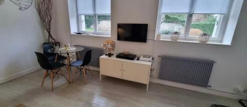 Una televisión o centro de entretenimiento en La Maison du Bonheur