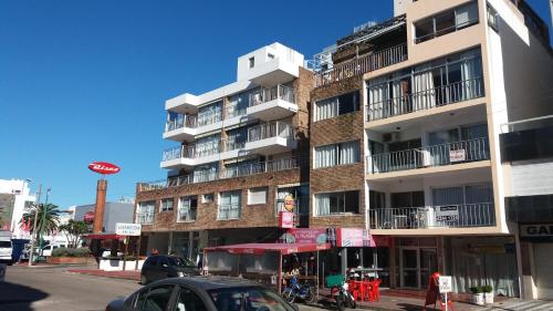 a tall building on a street with cars parked in front at Apartamento Punta del Este in Punta del Este