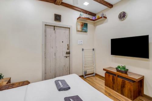 a bedroom with a bed and a flat screen tv at Pebble Studio Bandra W The Bombay Home Company - Eco in Mumbai