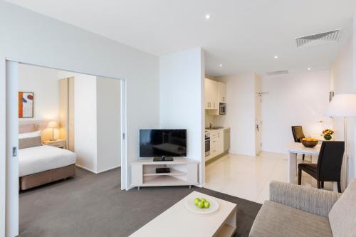 墨尔本Oaks Melbourne on Lonsdale Suites的带沙发、电视和床的客厅