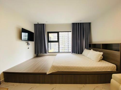 a bedroom with a large bed with a window at Shi House - Studios Building GH6 Near Vincom& Park in Long Bình