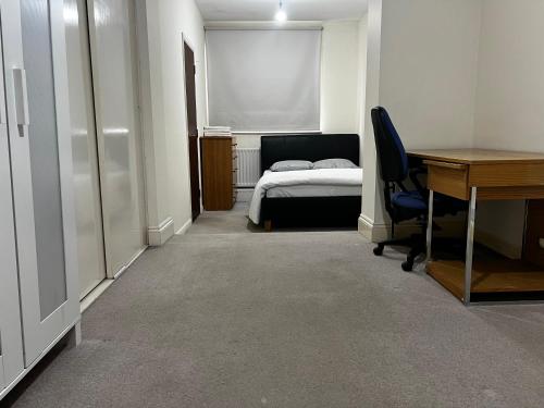 a room with a desk and a bed and a desk sidx sidx sidx at Budget Stay In Luton 02 03 in Luton