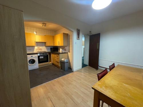 a kitchen with yellow cabinets and a table in a room at Budget Stay In Luton 02 03 in Luton