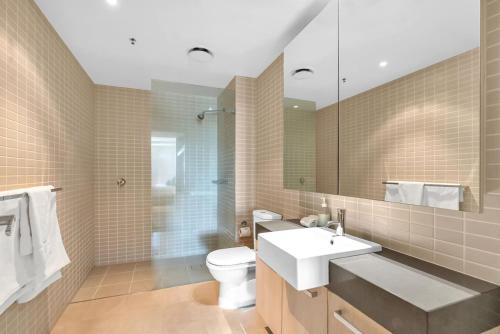 a bathroom with a sink and a toilet and a mirror at Cairns Coastal Charmer - Your Waterfront Sanctuary in Cairns