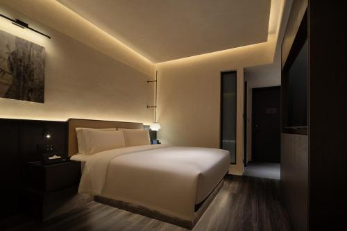 a bedroom with a large white bed in a room at Yomanju International Hotel -Guangzhou Tower Zhujiang NewTown Sports West Road Branch &地铁站- Canton Fair Exclusive Rate in Guangzhou