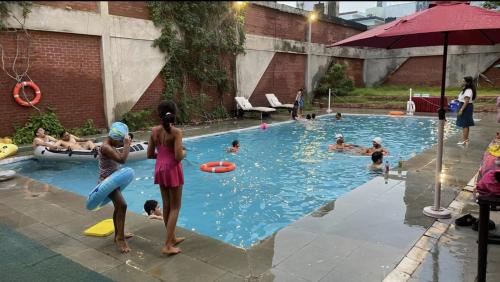 a group of people playing in a swimming pool at Taj Waves - Poolside Tent in a Peaceful Retreat in Agra