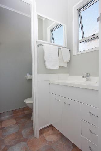 a white bathroom with a sink and a toilet at Coronation Park Holiday Park in Ashburton