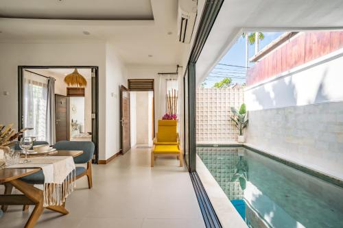 a house with a swimming pool and a dining room at Emerald Pura 2BR Villa - Private & Peaceful in Ungasan