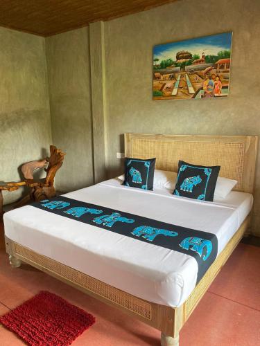 a bedroom with a large bed with blue pillows at Negombo Boutique Villa in Negombo