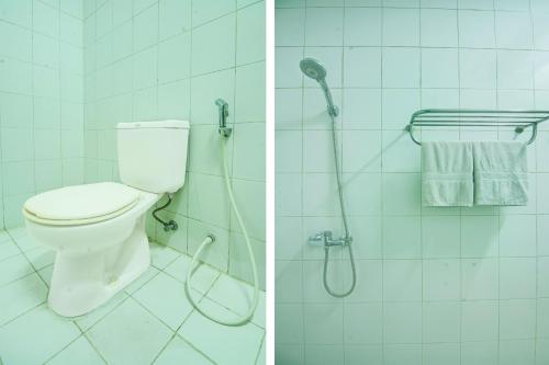 a bathroom with a toilet and a shower with a hose at Hotel O Makassar near Pantai Losari formerly Hotel Tiara Sari in Makassar