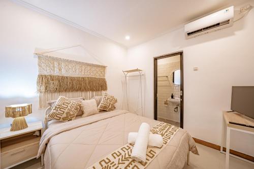 a bedroom with a large bed and a television at Emerald Pura 2BR Villa - Private & Peaceful in Ungasan