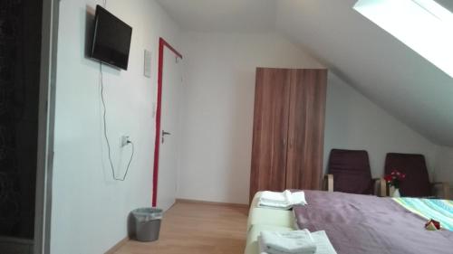 a bedroom with a bed and a tv on the wall at Hotel "Alte Schule" Trogen in Trogen
