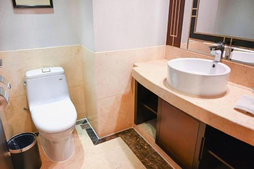 a bathroom with a toilet and a sink at Royal Tulip Hotel Zhujiajiao Shanghai in Shanghai